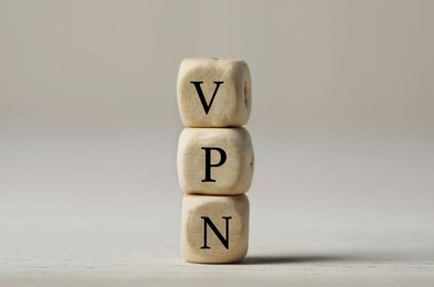 Photo of Wooden beads with acronym VPN on light background