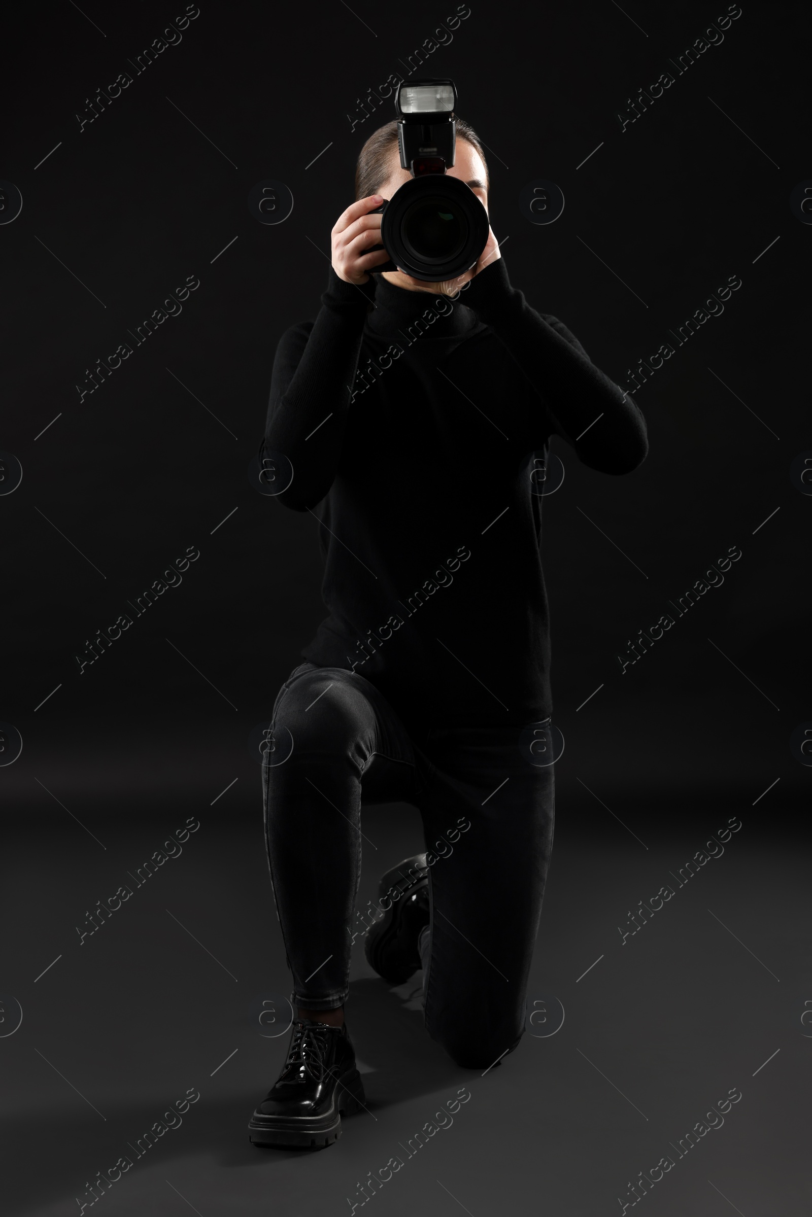 Photo of Professional photographer taking picture on black background