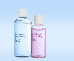 Bottles of cleansing gels on light blue background. Makeup remover 