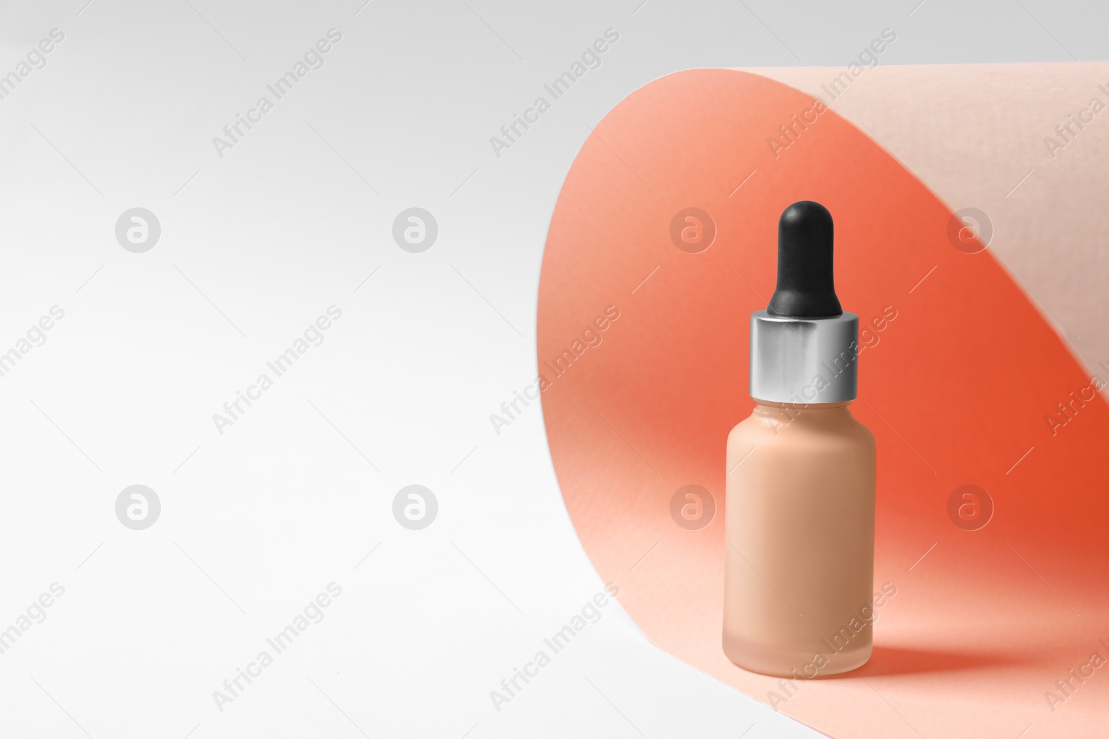 Photo of Bottle of skin foundation on color background, space for text. Makeup product