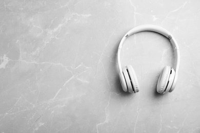 Photo of Stylish modern headphones and space for text on gray background, top view