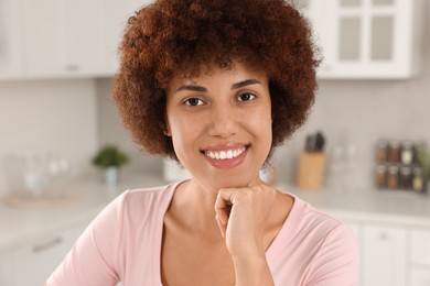 Photo of Portrait of happy young woman in kitchen