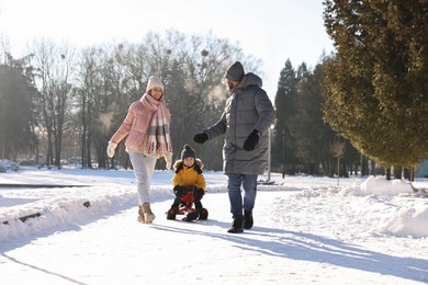 Happy family walking in sunny snowy park