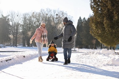 Photo of Happy family walking in sunny snowy park