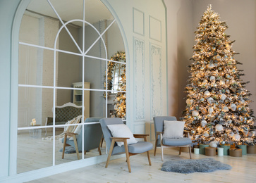 Festive room interior with stylish furniture and beautiful Christmas tree