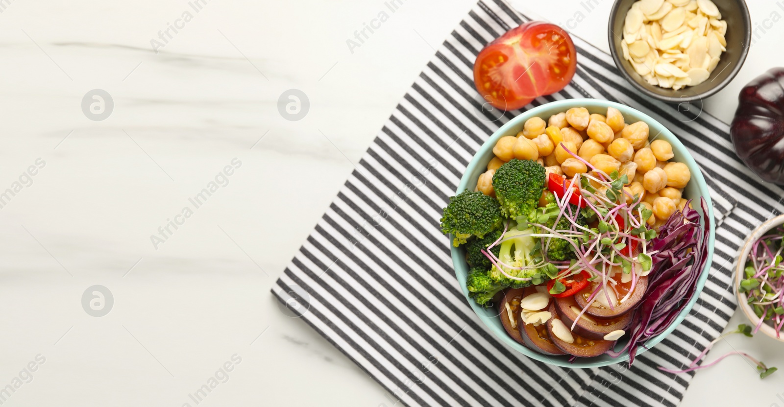 Image of Delicious vegan bowl with broccoli, red cabbage and chickpea on white marble table, flat lay. Banner design with and space for text