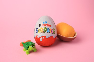Photo of Slynchev Bryag, Bulgaria - May 25, 2023: Kinder Surprise Eggs, plastic capsule and toy turtle on pink background