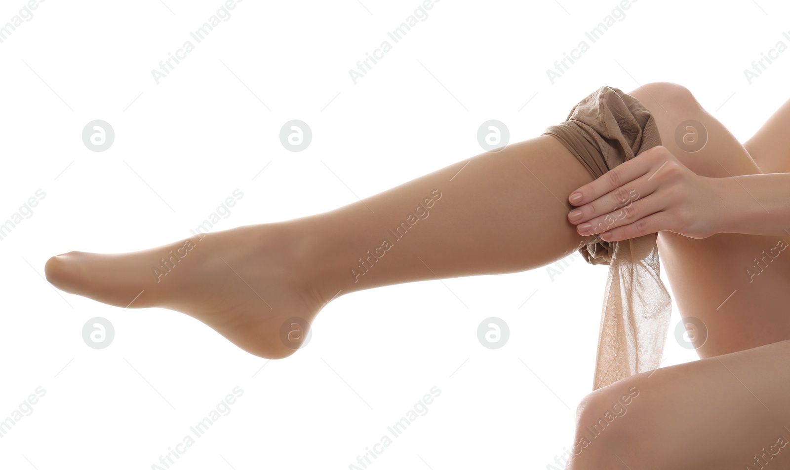 Photo of Young woman putting on tights against white background, closeup