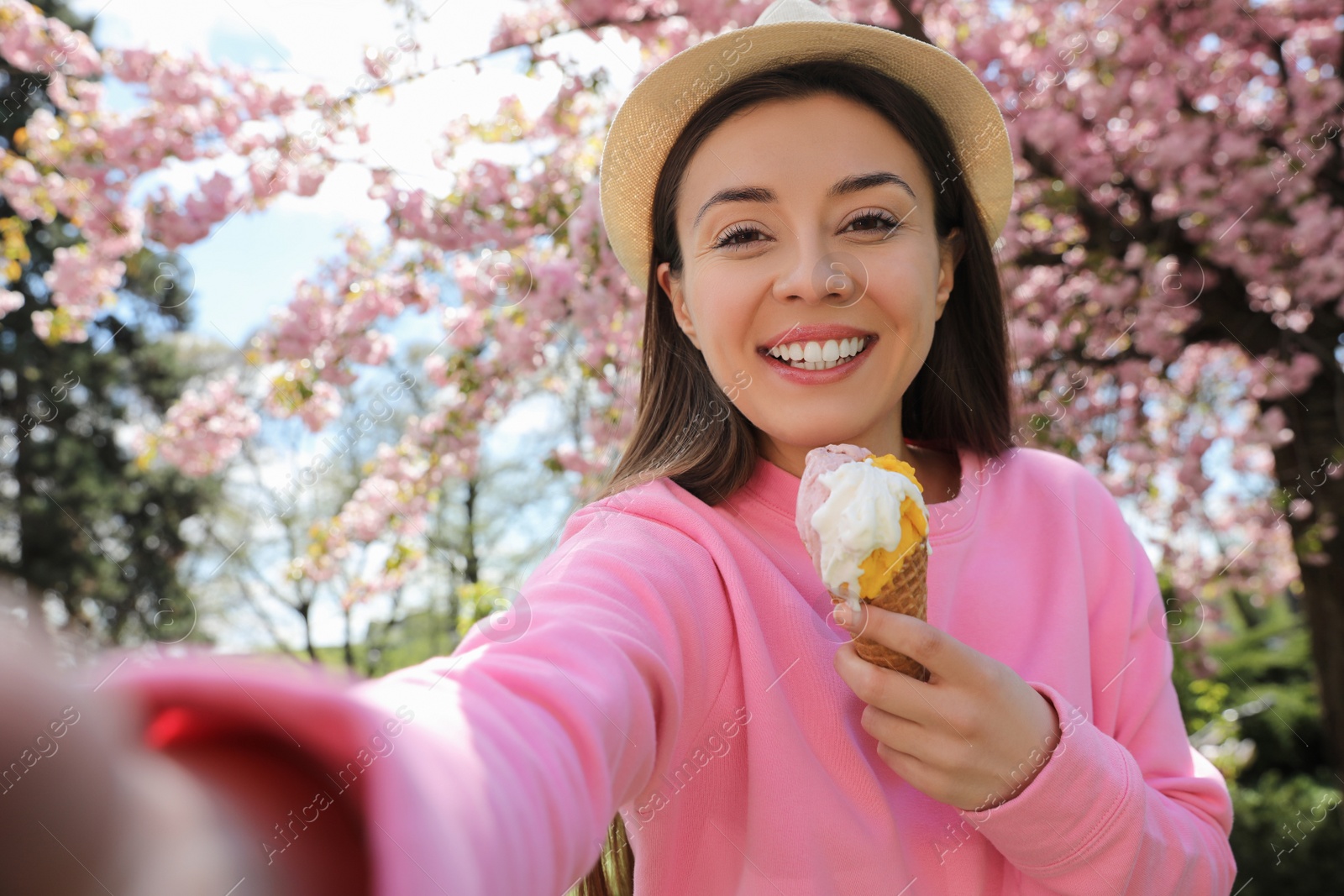 Photo of Happy woman taking selfie with ice cream in spring park