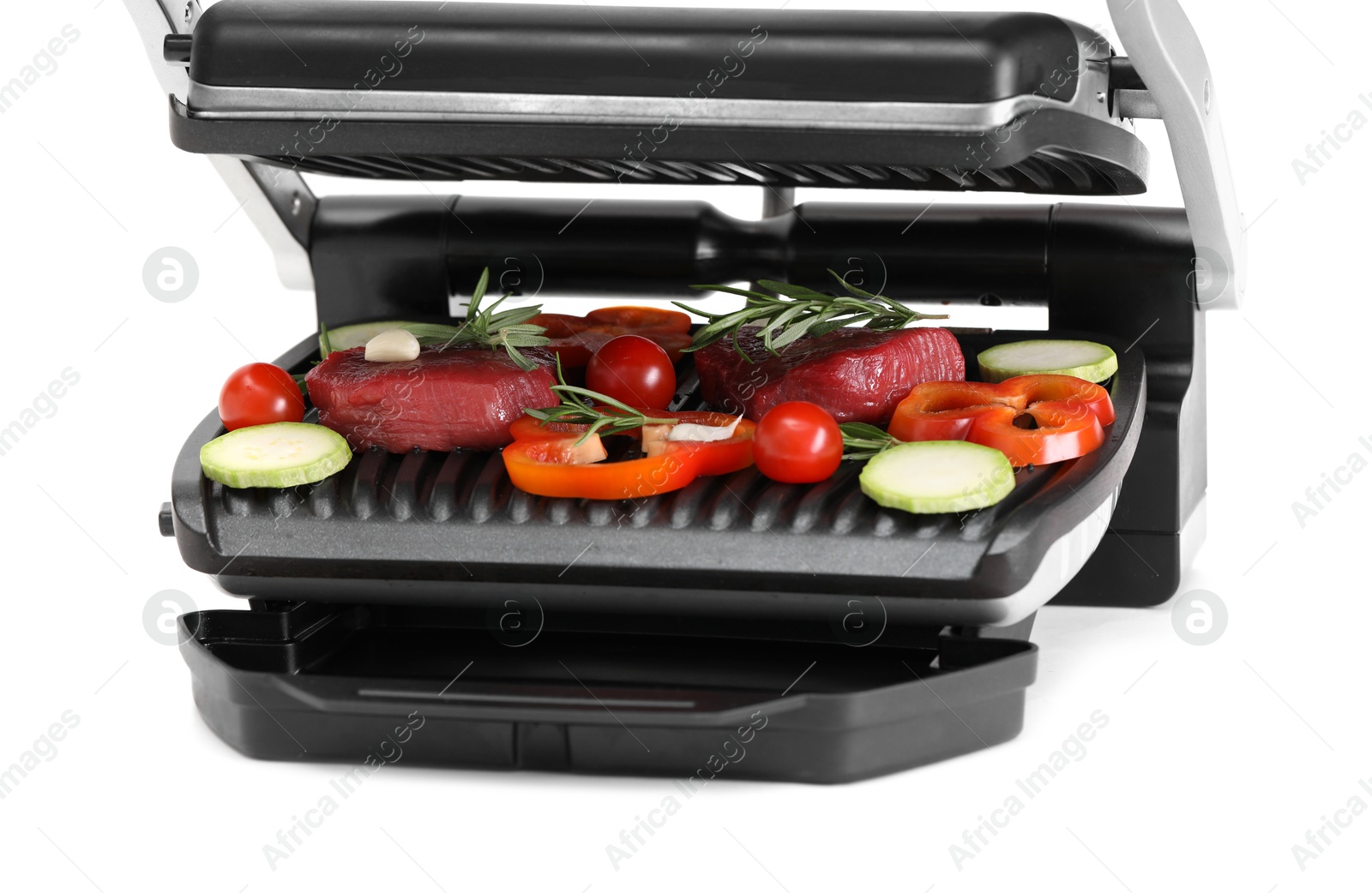 Photo of Electric grill with raw meat, rosemary and vegetables isolated on white