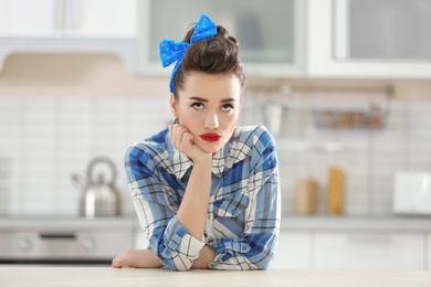 Portrait of funny young housewife in kitchen