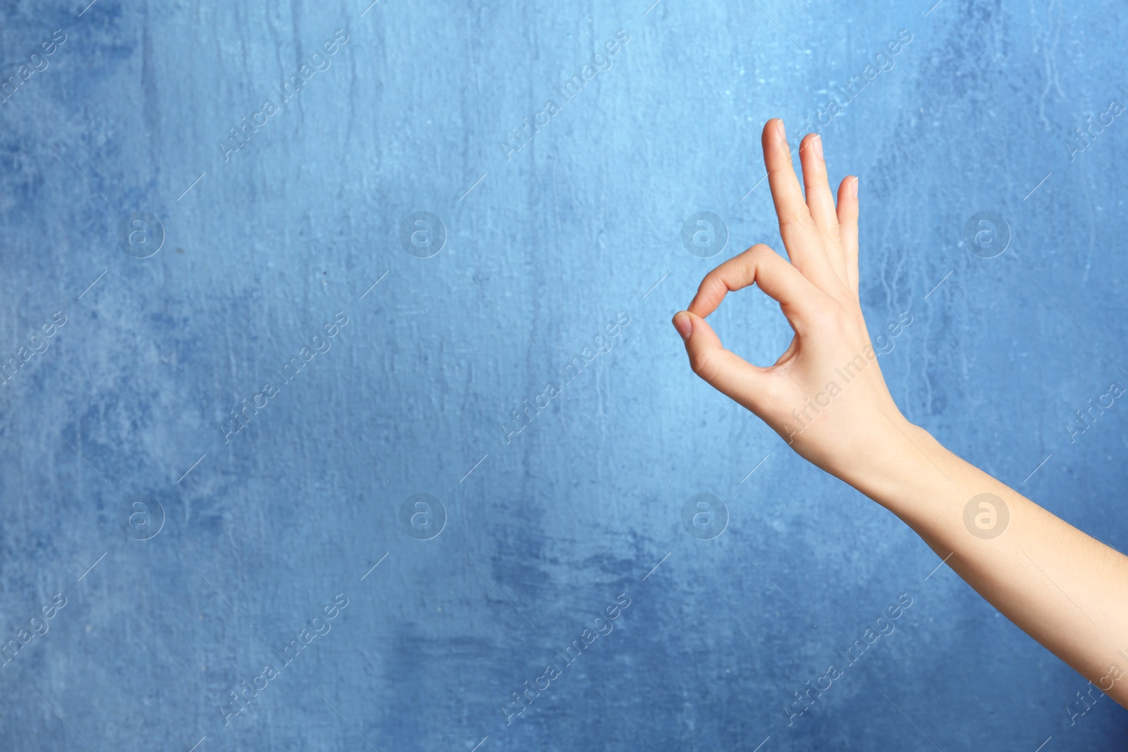 Photo of Woman showing okay gesture on color background, space for text