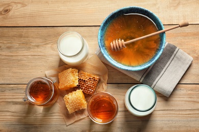 Photo of Composition with milk and honey on wooden background, top view