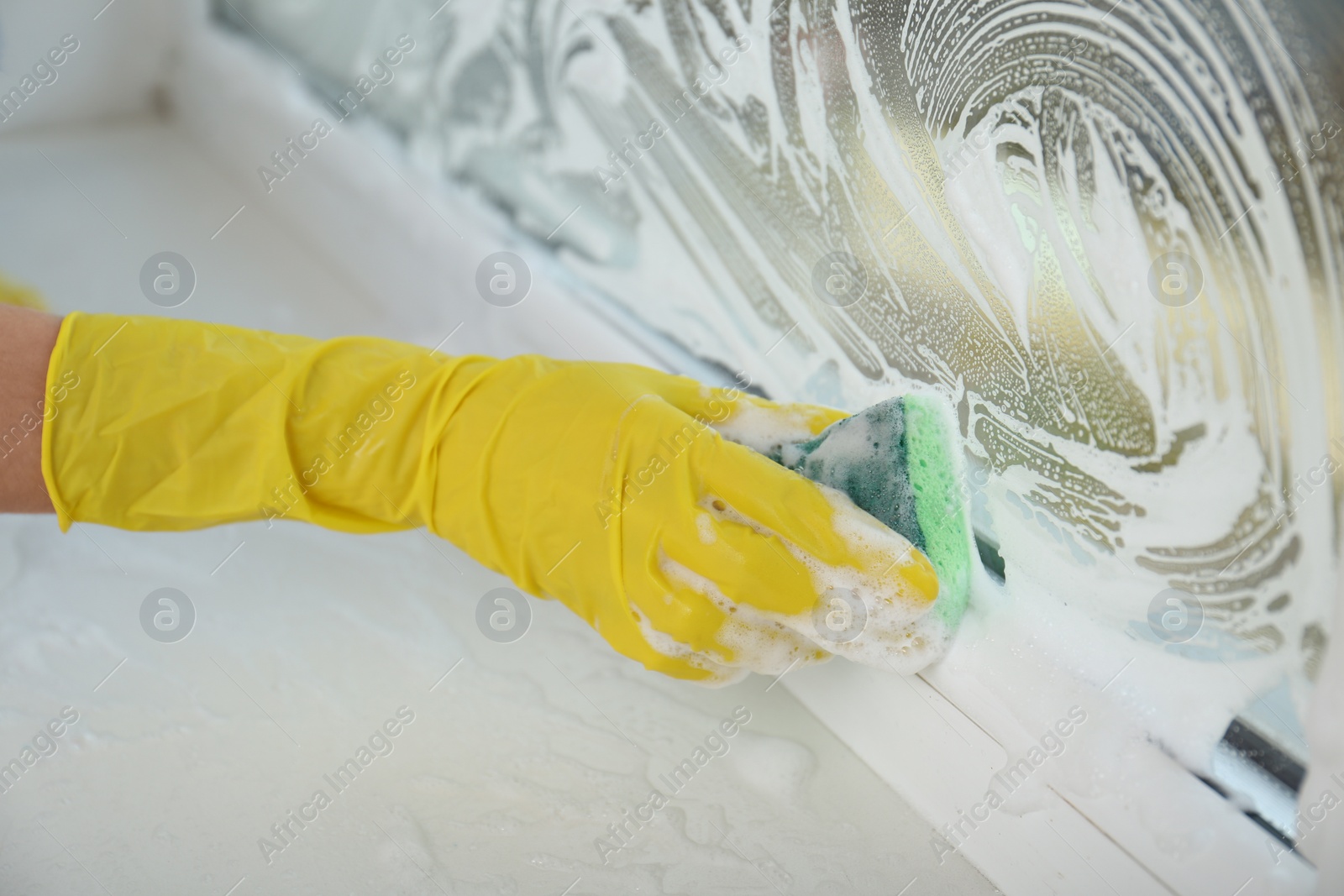 Photo of Woman cleaning window with sponge, closeup view