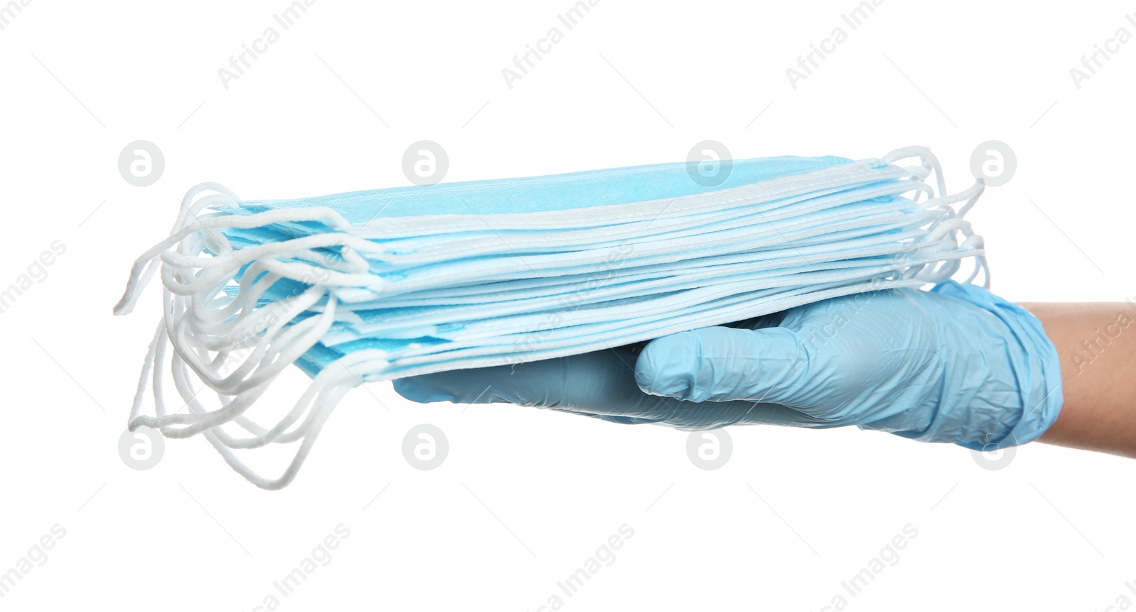 Photo of Doctor in latex gloves holding disposable face masks on white background, closeup. Protective measures during coronavirus quarantine