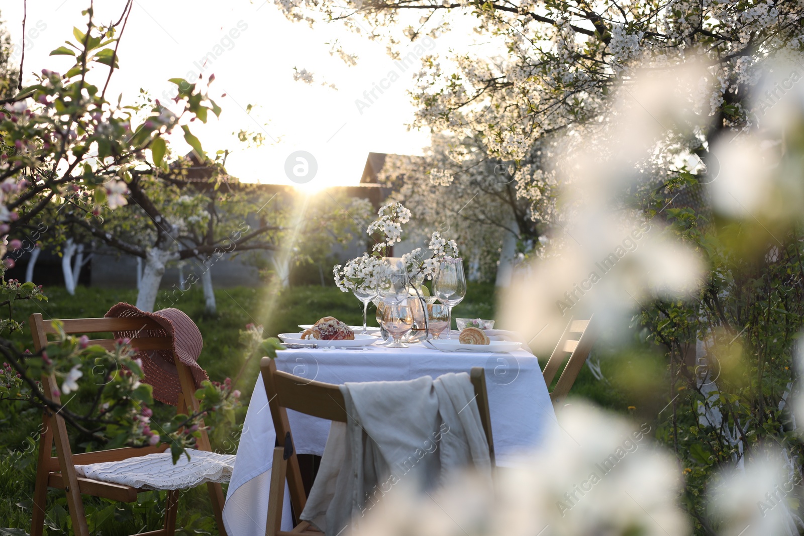 Photo of Stylish table setting with beautiful spring flowers in garden