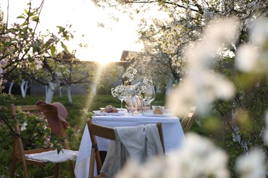 Photo of Stylish table setting with beautiful spring flowers in garden