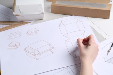 Photo of Woman creating packaging design at table, closeup