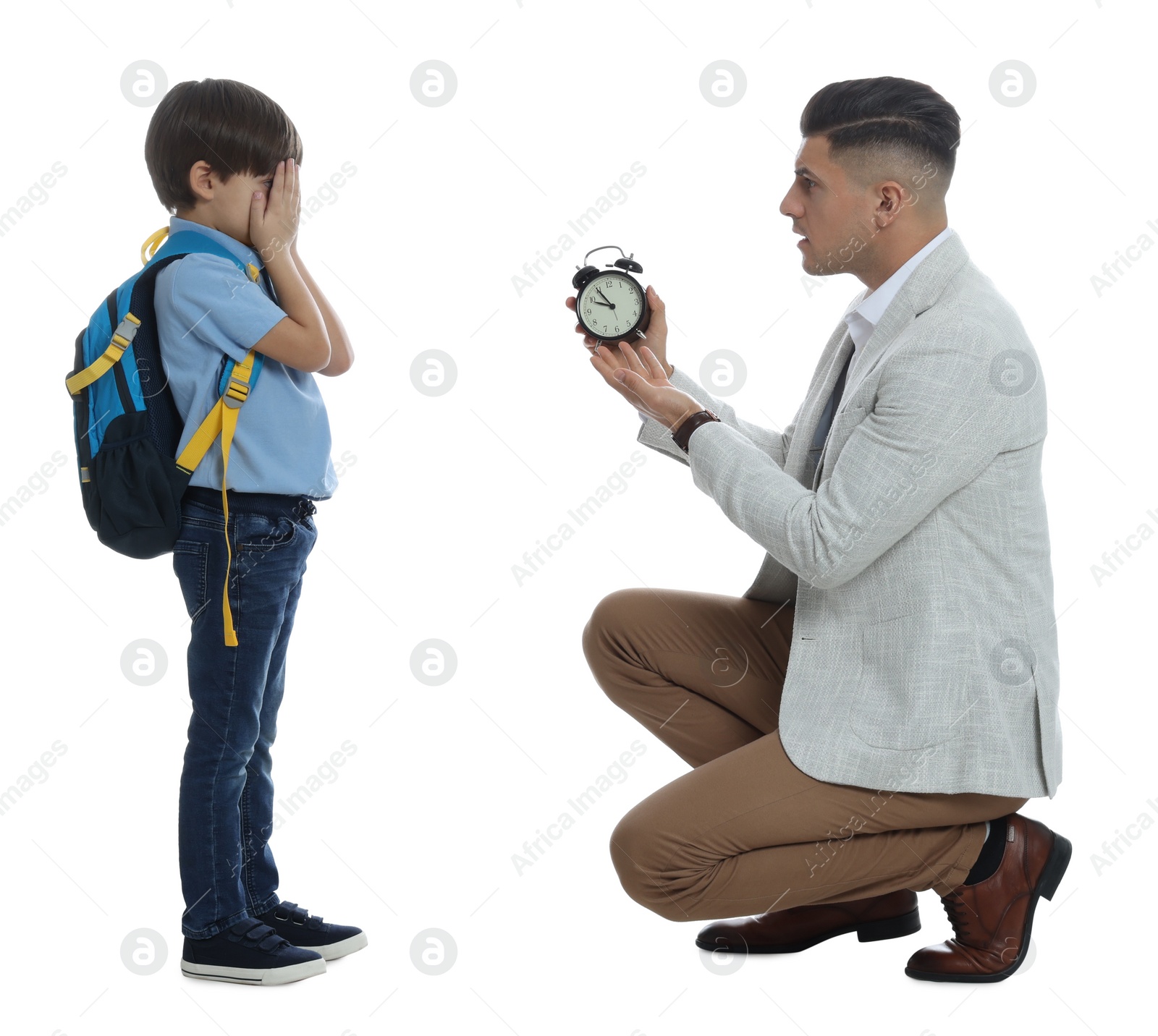 Photo of Teacher with alarm clock scolding pupil for being late against white background