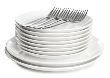 Photo of Stack of ceramic dishware with cutlery on white background