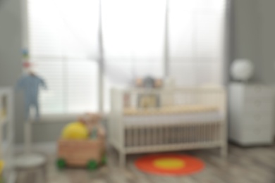 Blurred view of baby room with stylish furniture