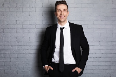 Male real estate agent on brick wall background