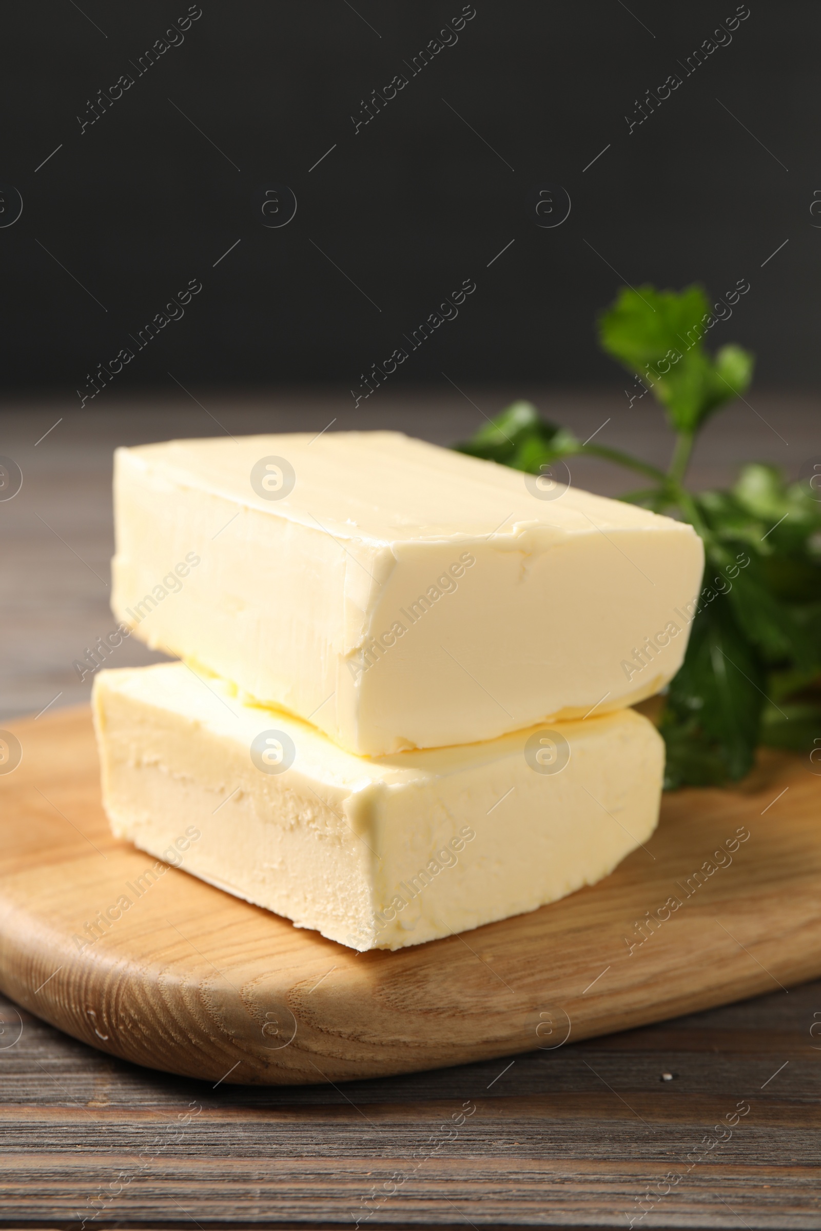 Photo of Tasty butter and parsley on wooden table, closeup