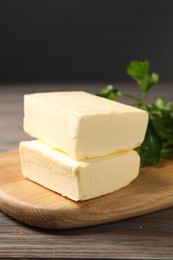 Photo of Tasty butter and parsley on wooden table, closeup