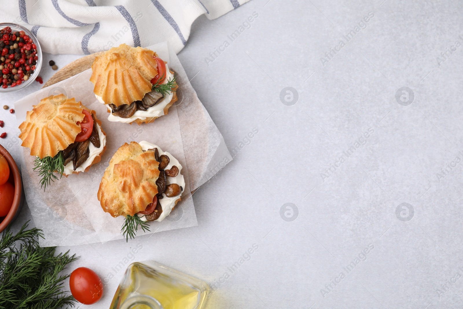 Photo of Delicious profiteroles and ingredients on white table, flat lay. Space for text