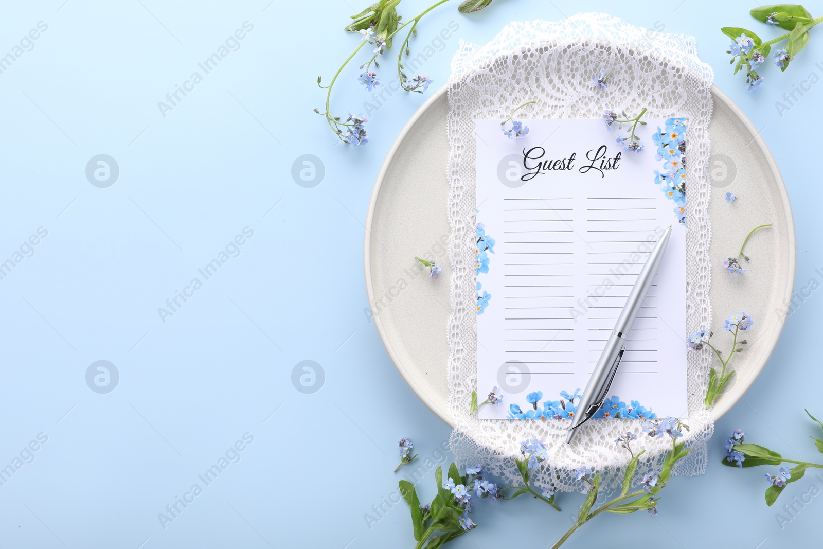 Photo of Plate with guest list, pen, lace and flowers on light blue background, flat lay. Space for text