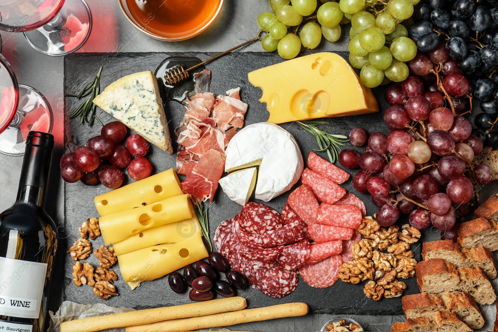 Photo of Flat lay composition with wine and snacks on grey background