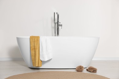 Stylish bathroom interior with ceramic tub and terry towels