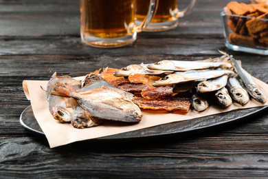 Tasty dried fish on black wooden table