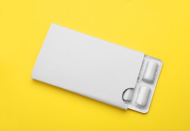 Blister with chewing gums on yellow background, top view