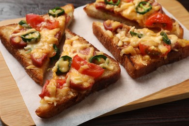 Photo of Tasty pizza toasts served on wooden table, closeup