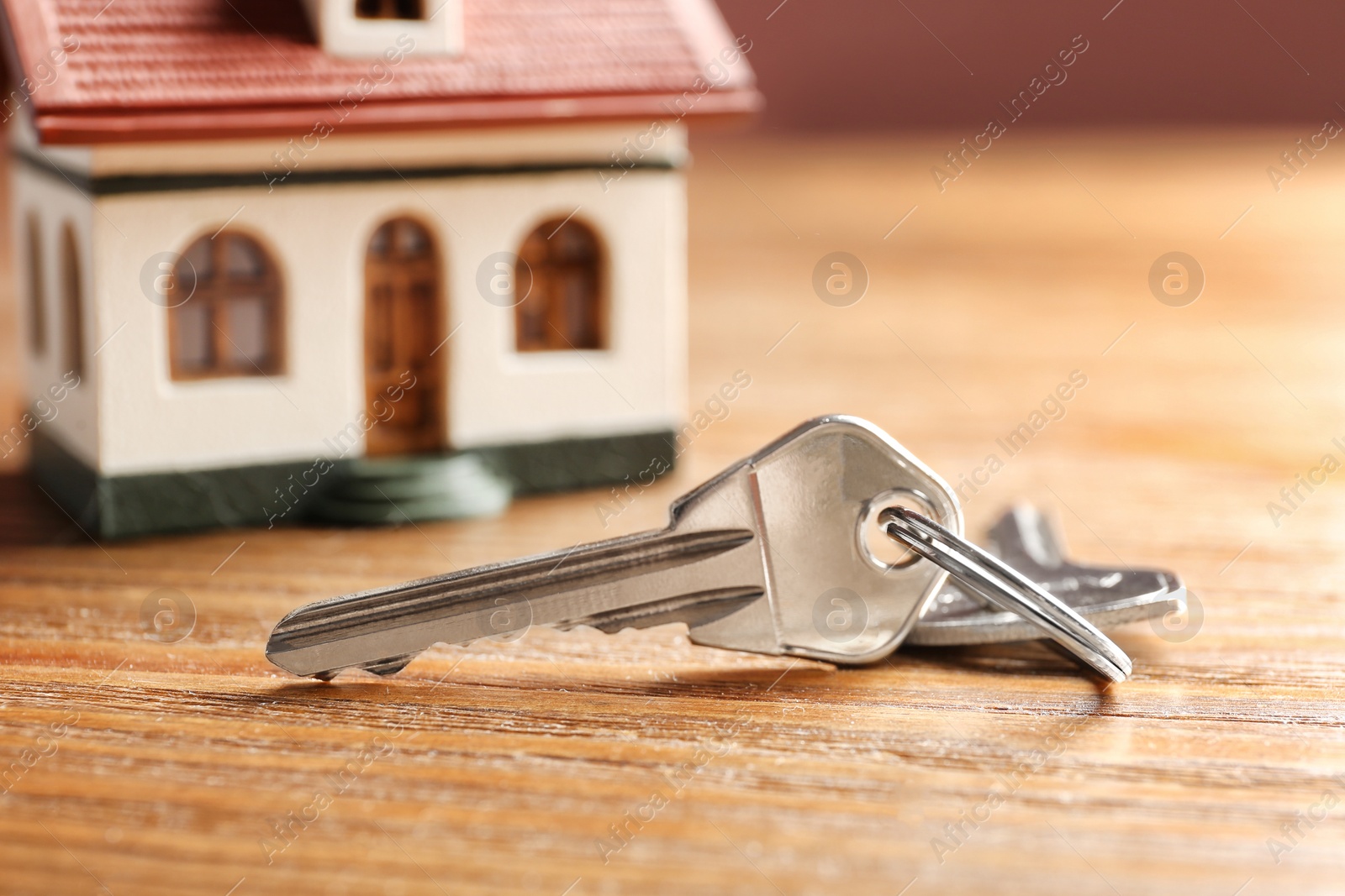 Photo of Keys on wooden table. Real estate agent services