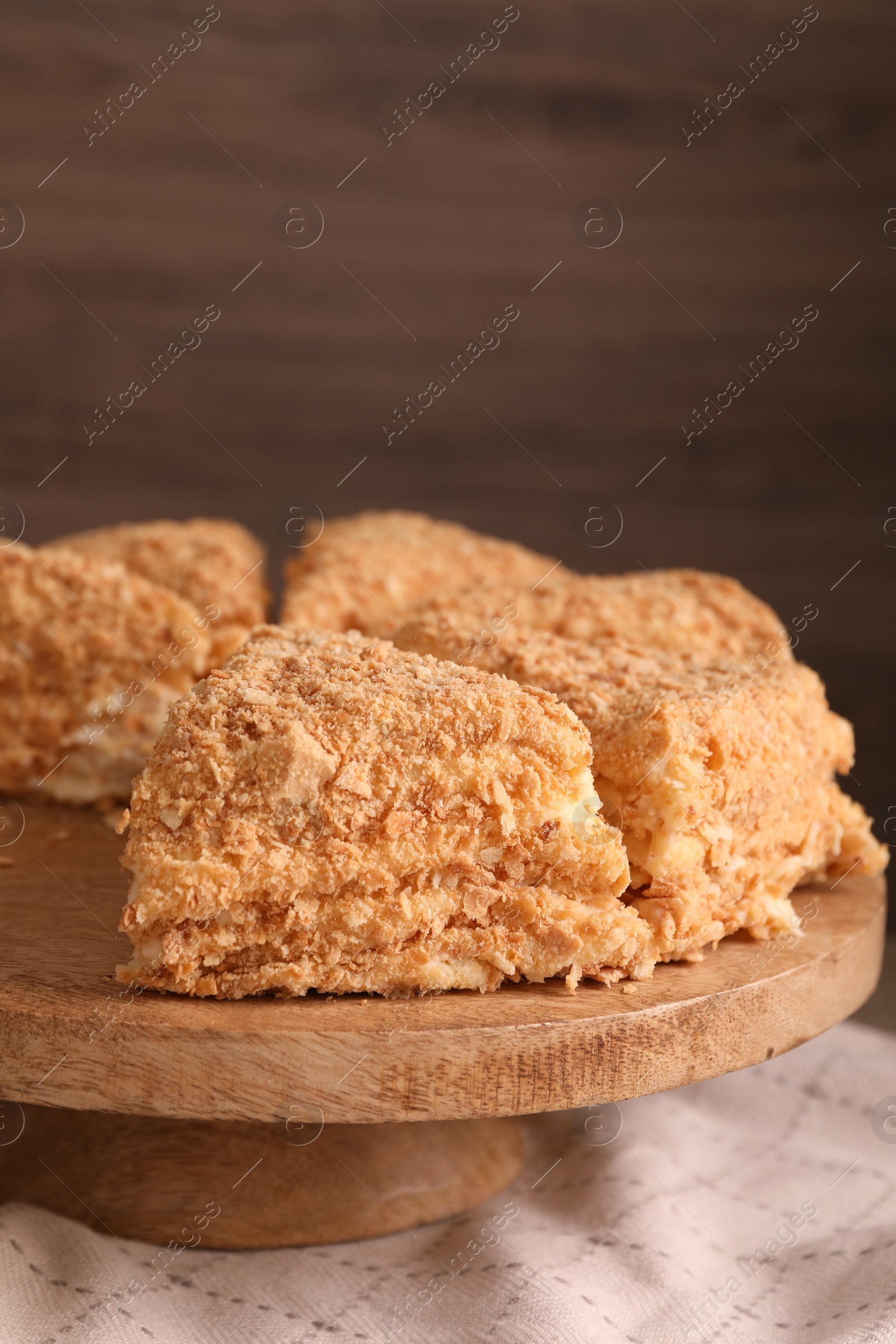 Photo of Pieces of delicious Napoleon cake on table, closeup. Space for text