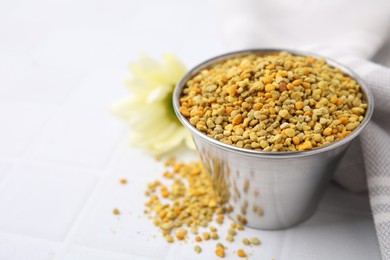Fresh bee pollen granules on white table, closeup. Space for text
