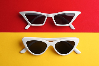 Stylish sunglasses on color background, above view. Summer time
