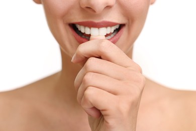 Woman with beautiful lips biting her finger on white background, closeup