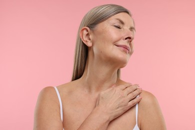 Beautiful woman with healthy skin on pink background