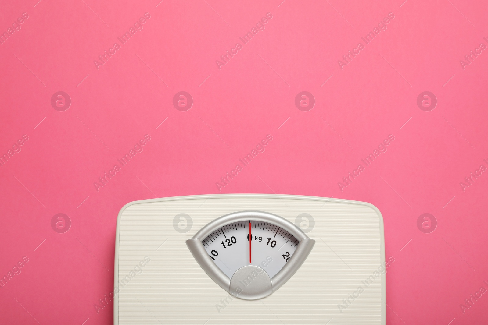 Photo of Weigh scales on pink background, top view with space for text. Overweight concept