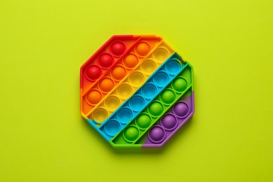 Photo of Rainbow pop it fidget toy on light green background, top view