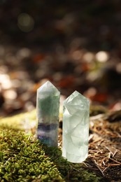 Beautiful quartz crystals on green moss in forest. Space for text