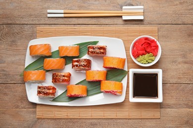 Flat lay composition with delicious sushi rolls on wooden table