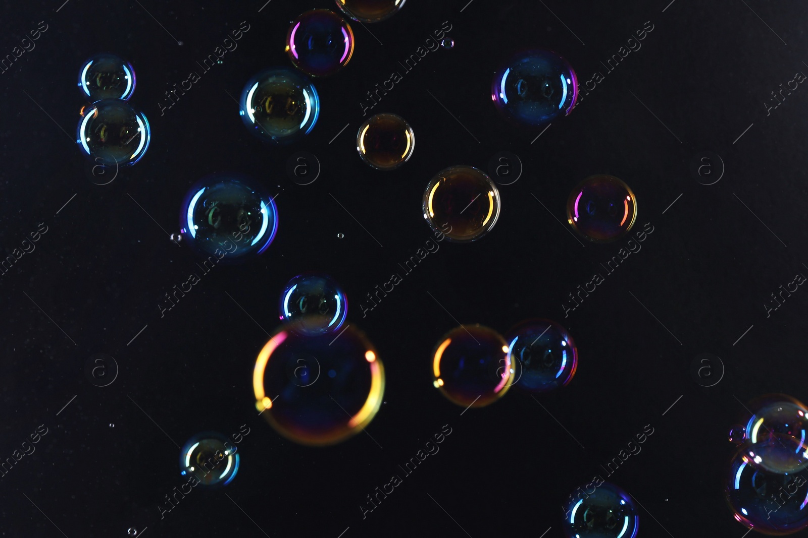 Photo of Beautiful transparent soap bubbles on dark background