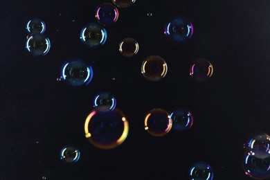 Photo of Beautiful transparent soap bubbles on dark background