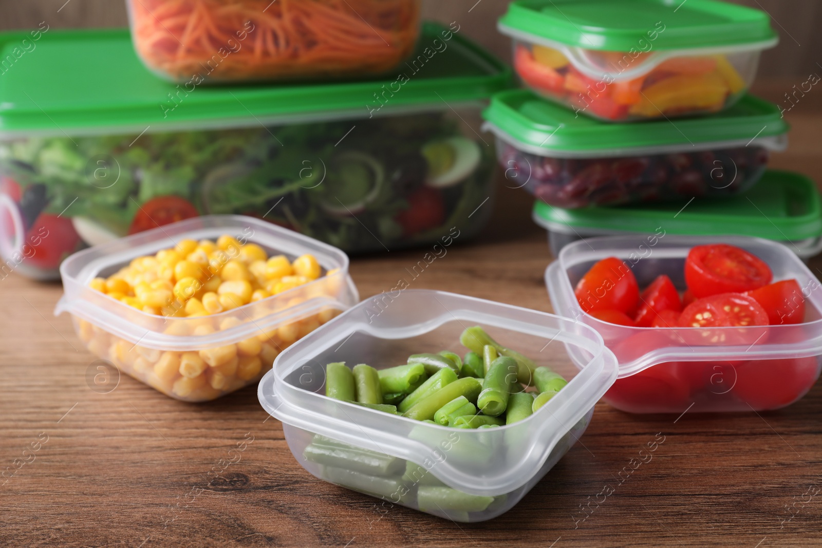 Photo of Set of plastic containers with fresh food on wooden  table