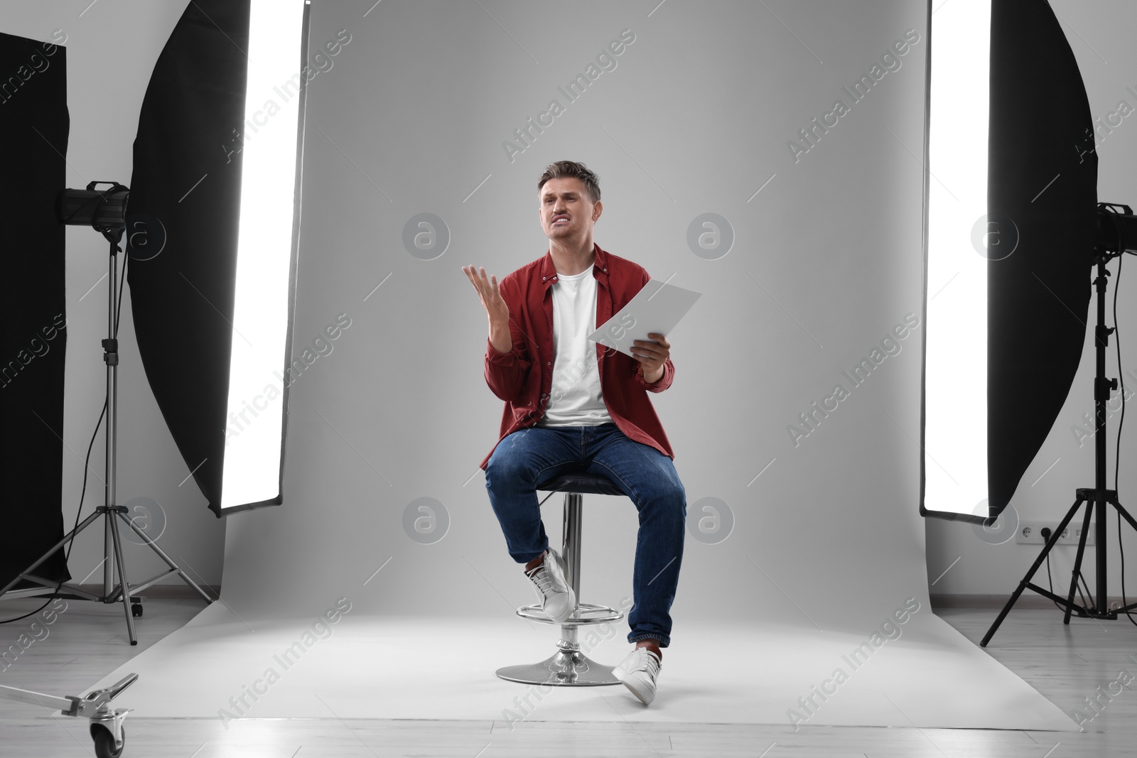 Photo of Casting call. Emotional man with script performing in studio