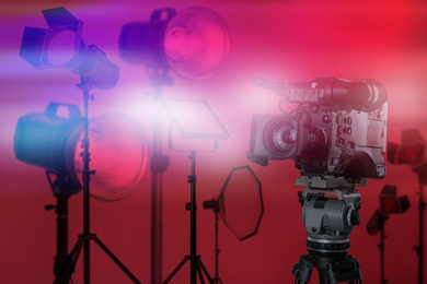 Image of Modern professional video camera and lighting equipment in studio
